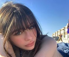 a woman laying on top of a beach next to the ocean