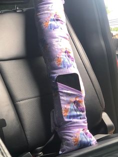 the seat belt is covered with purple fabric and has pictures of princesses on it