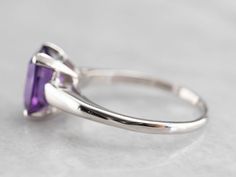 "This stunning vintage amethyst ring has a pretty deep purple amethyst in the center, that really flashes and flickers with vibrant violet reflections! Set into a lovely and utterly simple platinum ring with four protective corner prongs, this vintage ring is a beautiful addition to anyone's collection! Metal: Platinum Gem: Amethyst 2.12 Carats Gem Measurements: 9.0 x 6.8 mm, Emerald Cut Ring Size: 8 Marks: \"100%IRIDPLAT\" Stamped on the inside band SKU #: EJFW97UR Each piece has been identifie Classic Amethyst Birthstone Ring With Accent Stones, Classic Purple Sapphire Ring With Prong Setting, Classic Lavender Amethyst Ring With Prong Setting, Formal Purple Birthstone Ring With Prong Setting, Classic Purple Amethyst Ring With Prong Setting, Emerald Cut Amethyst Ring For Anniversary, Purple Amethyst Ring With Emerald Cut And Gemstone Accents, Purple Solitaire Amethyst Ring For Anniversary, Purple Emerald Cut Amethyst Ring With Gemstone Accents