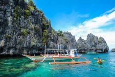 a boat in the water near some rocks