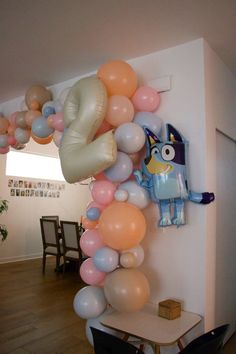 balloons are hanging from the wall near a table