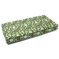 a green and white flowered dog bed on a white background with the cover folded up