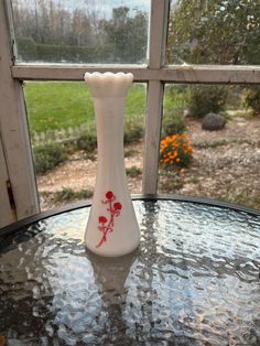 a white vase sitting on top of a glass table