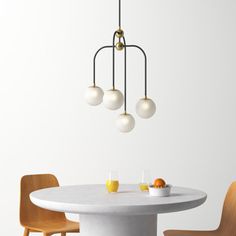 a white table with four chairs and a light fixture hanging from it's ceiling