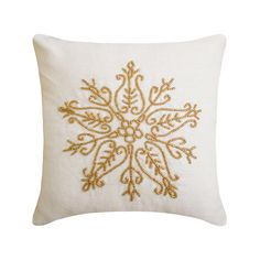 a white pillow with gold embroidered snowflake on it