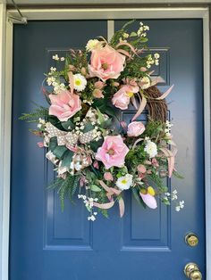 a blue door with a wreath and flowers on it