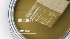 a can of paint with the words thai curry on it and a brush in front of it