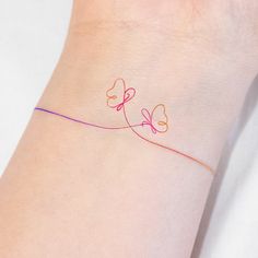 a woman's wrist with two hearts on it and an orange line in the middle