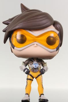 a close up of a figurine wearing a yellow outfit and goggles with brown hair