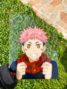 an anime character with pink hair holding up a photo in front of some green plants