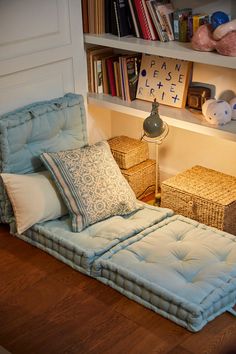 a bed that is in the middle of a room with bookshelves behind it