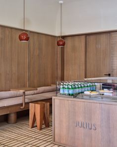 the interior of a restaurant with wooden booths and tables, along with drinks on display