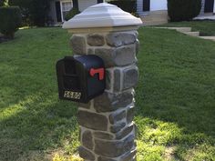 a mailbox on the side of a stone pillar