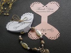 two tags are on top of a table with some beads and charms around them,