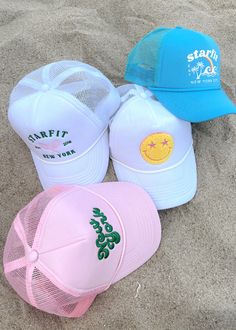 Starfit trucker hats! Offered in 4 styles. Mesh back with adjustable snapback. Terry fabric lines the inside for ultra comfort and sweat wicking. Smiley: white hat with chenille embroidery New York: light pink hat with 3D embroidery Varsity: white hat with embroidery Tropics: teal blue hat with print Pink Trucker Hat Aesthetic, Cute Hats For Summer, Pink Trucker Hats, Trucker Hat Trendy, Cute Summer Hats For Women, Cute Beach Hat, Beachy Trucker Hats, Custom Trucker Hats Design, Aesthetic Trucker Hats