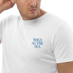 ️ Surfer T-shirt with embroidered "WILD AS THE SEA" lettering on the left chest. 🌊 Minimalist design for water sports, beach, vacation and ocean enthusiasts. Made from 100% organic ring-spun cotton, this unisex t-shirt is a must-have. It's high quality, super comfortable and best of all - environmentally friendly. Material: * 100% ring-spun organic cotton * Fabric weight: 180 g/m² (5.3 oz./yd.²) * Single jersey * Medium fit * Adjusted sleeves * 1 × 1 ribbing on the collar * Wide double seams on White Embroidered Logo T-shirt For Summer, Relaxed Fit T-shirt With Embroidered Logo For Summer, White Relaxed Fit T-shirt With Letter Embroidery, White Letter Embroidery T-shirt For Streetwear, Summer Tops With Relaxed Fit And Embroidered Logo, Relaxed Fit Top With Embroidered Logo For Summer, Summer T-shirt With Letter Embroidery And Short Sleeves, Summer Short Sleeve T-shirt With Letter Embroidery, Casual Summer T-shirt With Letter Embroidery