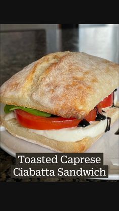 a close up of a sandwich on a plate with cheese and tomatoes in the middle