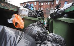 there are many garbage bags in the back of this dumpster's bins