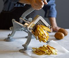 a person using a french fryer to cut up bananas