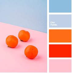 three oranges sitting on top of a pink and blue table next to each other