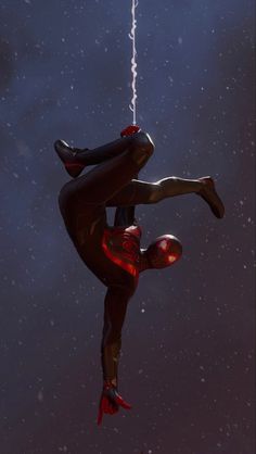 a spider - man hanging upside down in the air with his hands on his hips