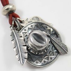 Pendentif en argent sterling forgé à la main avec un cordon en cuir de 35 pouces. Cette pièce comprend un pendentif oiseau-tonnerre, un pendentif en plume d'aigle et un pendentif chapeau de cowboy en trois dimensions serti de turquoise numéro huit naturelle.

 Dimensions des plumes : 0,5" de largeur, 2" de hauteur
 Dimensions du chapeau : 1,75" de largeur, 2,25" de hauteur
 Dimensions de Thunderbird : 1" de largeur, 1,75" de hauteur Thunderbird 1, Bola Tie, Eagle Feather, Number Eight, Natural Number, Eagle Feathers, Chapeau Cowboy, Zuni Jewelry, Navajo Rugs