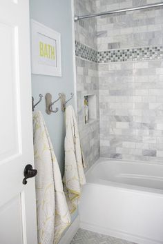 a bathroom with two towels hanging on the wall and a bathtub next to it