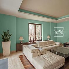 a living room with green walls and white couches in it's center area