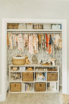 an organized closet with baskets and clothes hanging on the wall, next to a teddy bear