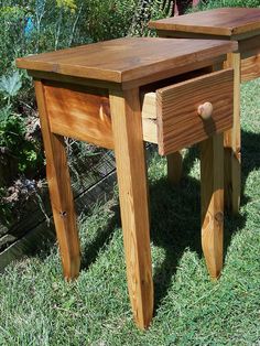 two wooden tables sitting in the grass