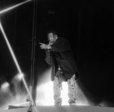 a man standing on top of a stage with his hands out in front of him