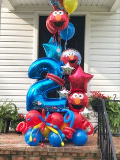 the balloons are in the shape of numbers and characters on the front steps of a house