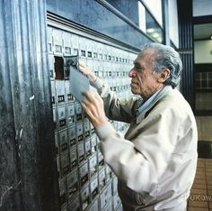 an old man is looking at some type of mailbox