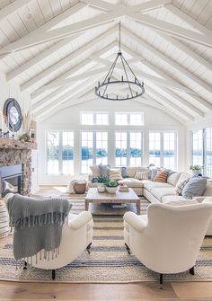 a living room filled with furniture and a fire place in the middle of an open floor plan