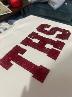 a t - shirt that has the letters s and p on it with red glitter