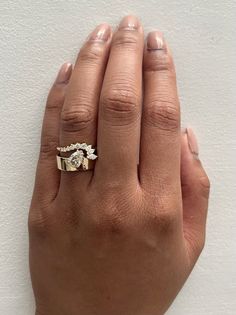 a woman's hand with a gold ring on top of her left hand and a diamond in the middle