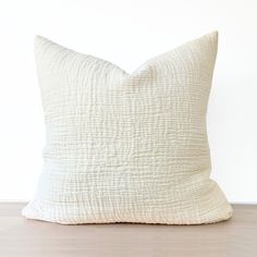 a white pillow sitting on top of a wooden floor