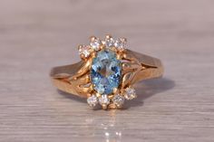 This stunning piece, known as The Sky Glow, features a vibrant oval-shaped blue topaz at its center. Surrounding the topaz are natural diamonds, totaling 0.08 carats, that enhance the brilliance of the gemstone and add a touch of elegance. The topaz, with its tranquil blue hue, is beautifully set in 14 karat yellow gold, creating a warm contrast that highlights the beauty of both the stone and the metal. The ring is crafted in 14 karat yellow gold and is currently a finger size 6.25 yet can be adjusted to any finger size for an additional charge upon request, ensuring a perfect fit. Love this piece, but don't have the money to spend right now? We offer FREE layaway on every item in our shop. With just 20% down, take one full year (interest-free) to pay off your new jewelry! There are no hi Tranquil Blue, Natural Diamond Ring, Rings Statement, Blue Topaz, The Sky, Favorite Jewelry, Natural Diamonds, Statement Rings, Topaz