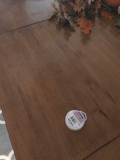 a remote control sitting on top of a wooden floor next to a potted plant