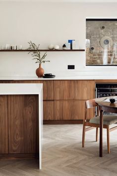 a modern kitchen with wooden cabinets and white counter tops, an oven in the back