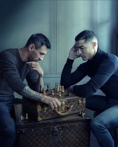 two men sitting next to each other with chess pieces on top of their chestes