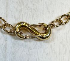 a close up of a gold chain on a white surface