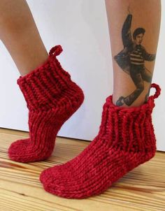 a woman's legs with tattoos and red knitted socks