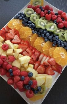 fruit platter with oranges, strawberries, blueberries and kiwi on it