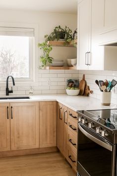 a kitchen with wooden cabinets and stainless steel stove top oven, dishwasher and window