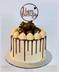 a birthday cake with white frosting and chocolate decorations