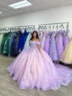 a woman is standing in front of some dresses