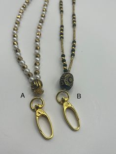 Hand crafted beaded lanyards with easy to use over sized gold lobster clasps. Makes swapping out your lanyard for badges and work ID's easy. Great for gifting in the workplace. One has a detailed gold style rose beads and the other a more tribal themed center bead. Both are easy to swap out and match outfits.  Want a special theme? Message me! Gold Metal Glasses Chains With Lobster Clasp, Adjustable Gold Glasses Chains With Lobster Clasp, Adjustable Beaded Chain Lanyard For Gift, Adjustable Metal Beaded Necklace With Lobster Clasp, Gold Beaded Metal Glasses Chains, Gold Necklaces With Round Beads For Fashion, Adjustable Beaded Chain Necklace For Everyday, Metal Beaded Necklaces With Lobster Clasp, Gold Metal Beaded Necklace With Lobster Clasp