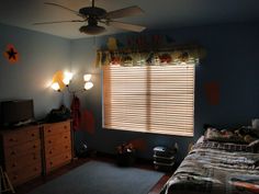 a bedroom with a bed, dresser and ceiling fan