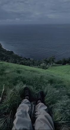 a person laying in the grass with their feet up